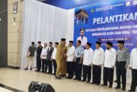 Plt Sekda Aceh M Nasir bersalaman dengan Ketua PPIH BTJ Azhari dan jajaran/mitra usai proses pelantikan di Aula Jeddah UPT Asrama Embarkasi Haji Aceh, Selasa (22/4/2025).