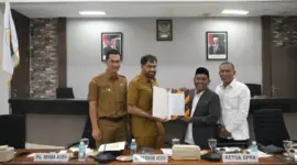 Gubernur Aceh Muzakir Manaf menerima draft revisi Undang-undang nomor 11 tahun 2006 tentang Pemerintahan Aceh dari Ketua Tim Revisi UUPA Tgk Anwar Ramli, di ruang serbaguna Dewan Perwakilan Rakyat Aceh, Senin (19/5/2025). Foto: Humas Aceh