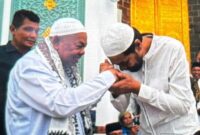 Gubernur Aceh menyalami Imam Besar Masjid Raya Baiturrahman (MRB), Tgk H. Muhammad Ali atau Abu Paya Pasi usai dilakukan pengukuhan di Masjid Raya Baiturrahman Banda Aceh Rabu (13/8/2025
