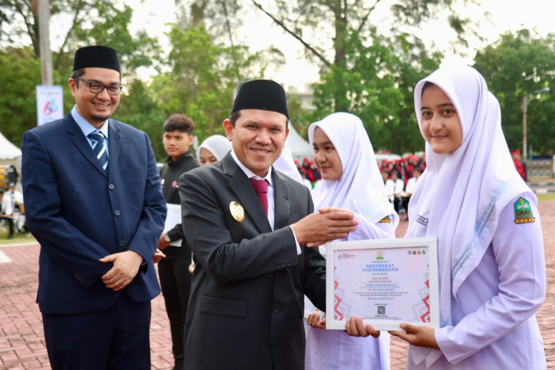 Wakil Gubernur Aceh, Fadhlullah, S.E., menyerahkan piagam penghargaan kepada siswa berprestasi tingkat nasional pada peringatan Hari Pendidikan Daerah (Hardikda) 2025 di halaman Kantor Gubernur Aceh, Selasa, (2/9/2025)