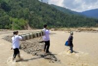 Warga Desa Pertik Kecamatan Pining Gayo Lues menyalurkan Makanan Bergizi kepada penerima manfaat yaitu anak sekolah, ibu hamil dan balita dengan menyeberangi sungai akibat jembatan putus diterjang banjir, Rabu (8/4/2026).