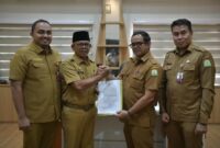 Penyerahan Surat Keputusan Pelaksana Tugas (Plt) Sekda Aceh kepada Taufik yang saat ini menjabat sebagai Kepala Dinas Perkim Aceh. Prosesi penyerahan SK tersebut berlangsung secara hybrid di dua tempat pada Senin (24/8/2026). Foto: Humas Aceh.