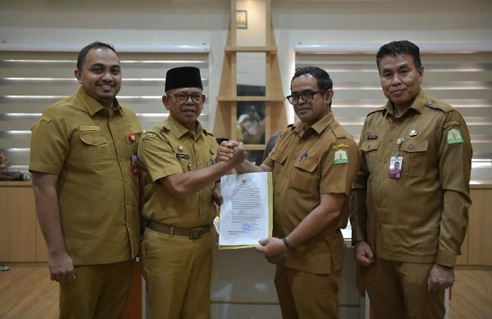 Penyerahan Surat Keputusan Pelaksana Tugas (Plt) Sekda Aceh kepada Taufik yang saat ini menjabat sebagai Kepala Dinas Perkim Aceh. Prosesi penyerahan SK tersebut berlangsung secara hybrid di dua tempat pada Senin (24/8/2026). Foto: Humas Aceh.