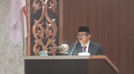 Pj. Sekda Aceh, Taufik, ST, M.Si, mewakili Gubernur Aceh Muzakir Manaf saat menyampaikan Nota Keuangan dan Rancangan Qanun Aceh tentang Anggaran Pendapatan dan Belanja Aceh (APBA) Tahun Anggaran 2027 dalam Rapat Paripurna Dewan Perwakilan Rakyat Aceh (DPRA), Senin (26/10/2026).(Foto Dok/Humas Aceh).