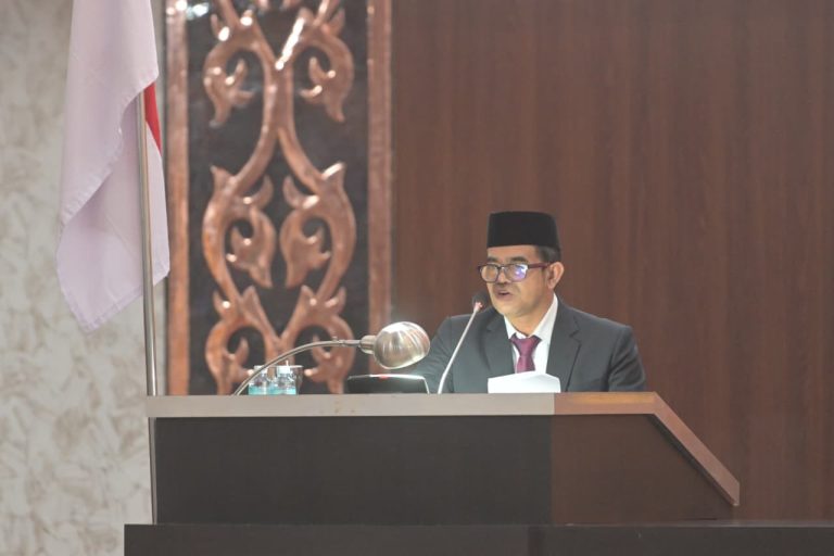 Pj. Sekda Aceh, Taufik, ST, M.Si, mewakili Gubernur Aceh Muzakir Manaf saat menyampaikan Nota Keuangan dan Rancangan Qanun Aceh tentang Anggaran Pendapatan dan Belanja Aceh (APBA) Tahun Anggaran 2027 dalam Rapat Paripurna Dewan Perwakilan Rakyat Aceh (DPRA), Senin (26/10/2026).(Foto Dok/Humas Aceh).